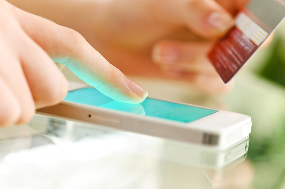 A person typing credit card details into their phone