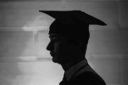 A student wears a graduation gown and cap